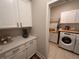 Functional laundry area with white cabinets, quartz countertops, and a modern washer and dryer setup at 9863 Summerlake Groves St, Winter Garden, FL 34787