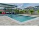 Inviting backyard featuring a sparkling pool, a cozy lounge area, and lush landscaping for relaxation and recreation at 9863 Summerlake Groves St, Winter Garden, FL 34787