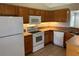 An efficient kitchen with modern appliances, ample wooden cabinetry, and tile flooring at 9923 Dean Acre Dr, Orlando, FL 32825