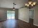 Bright living room with modern lighting, stylish wood-look floors, and sliding glass doors to the backyard at 9923 Dean Acre Dr, Orlando, FL 32825