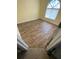 An empty room with hardwood floors and a unique arch window for ample natural light at 9923 Dean Acre Dr, Orlando, FL 32825