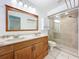 Bathroom featuring a double vanity, a large mirror, and a glass-enclosed shower at 10018 Chesham Dr, Orlando, FL 32817