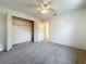Carpeted bedroom featuring a ceiling fan, an open closet, and a hallway at 10018 Chesham Dr, Orlando, FL 32817