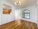 Hardwood dining area with chandelier and view of the kitchen, living room, and outdoor pool at 10018 Chesham Dr, Orlando, FL 32817