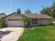 Charming single-story home with a well-maintained lawn, a two-car garage and mature trees at 10018 Chesham Dr, Orlando, FL 32817