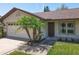 Close-up of the front of the home with a two-car garage, an entryway, and landscaping at 10018 Chesham Dr, Orlando, FL 32817