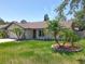 Inviting front yard view of the home, featuring a well-kept lawn, trees, and exterior at 10018 Chesham Dr, Orlando, FL 32817