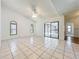 Open living room with vaulted ceiling, tile flooring, and sliding glass doors to outdoor patio and pool at 10018 Chesham Dr, Orlando, FL 32817