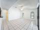 Bright living room featuring tile floors, ceiling fan, and large windows offering plenty of natural light at 10018 Chesham Dr, Orlando, FL 32817