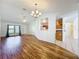 View of living room with hardwood floors, white walls, ceiling fans, and a view of the kitchen at 10018 Chesham Dr, Orlando, FL 32817