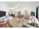 Bright living room featuring hardwood floors, a modern sofa, and stylish decor, flowing into the dining area at 10018 Chesham Dr, Orlando, FL 32817