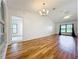 Spacious living room with hardwood floors and a chandelier looking into other living areas at 10018 Chesham Dr, Orlando, FL 32817