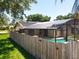 Screened-in pool with a view of the backyard and wooden fence at 10018 Chesham Dr, Orlando, FL 32817