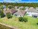 Aerial shot of a neighborhood with manicured lawns, mature trees, and a serene pond at 10091 Lovegrass Ln, Orlando, FL 32832