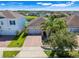Aerial shot of a home with a brick driveway, lush landscaping, and nearby community pond at 10091 Lovegrass Ln, Orlando, FL 32832