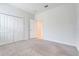 The bedroom features neutral carpet, a closet with folding doors, and white walls at 10091 Lovegrass Ln, Orlando, FL 32832