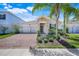 Charming single-story home featuring a brick driveway, stone accents, and mature landscaping at 10091 Lovegrass Ln, Orlando, FL 32832