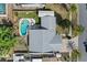 Aerial view showcasing the home with a gray roof, fenced backyard, and a sparkling blue pool surrounded by lush greenery at 109 Woodfield Ct, Sanford, FL 32773