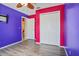 Bedroom showcasing striking purple and pink walls, a double closet, and an open doorway to another room at 109 Woodfield Ct, Sanford, FL 32773