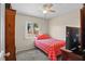 Cozy bedroom with a window, ceiling fan, and a bed with red patterned linens, complemented by matching furnishings at 109 Woodfield Ct, Sanford, FL 32773