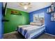 Vibrant bedroom with contrasting green and blue walls, showcasing a ceiling fan and a bed with striped bedding at 109 Woodfield Ct, Sanford, FL 32773
