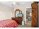 Bright bedroom featuring a dresser with a mirror, a ceiling fan, and an opening to a living area at 109 Woodfield Ct, Sanford, FL 32773