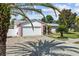 Charming home with a two-car garage, white exterior and pink accents, surrounded by beautiful palm trees at 109 Woodfield Ct, Sanford, FL 32773