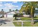 Charming single-story home with a lush front yard, white exterior with pink accents, and a two-car garage at 109 Woodfield Ct, Sanford, FL 32773