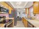 Modern kitchen featuring stainless steel appliances, wooden cabinets, and seamless flow into the living area at 109 Woodfield Ct, Sanford, FL 32773