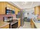 Kitchen featuring stainless steel appliances and light wood cabinetry with sightlines to the living room at 109 Woodfield Ct, Sanford, FL 32773