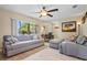 Bright living room with cozy seating, wood floors, and natural light from a large window at 109 Woodfield Ct, Sanford, FL 32773