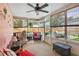 Relaxing sunroom with a ceiling fan, wicker furniture, and a view of the pool and fenced backyard at 109 Woodfield Ct, Sanford, FL 32773