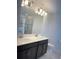 Modern bathroom featuring a double sink vanity, large mirror, and sleek lighting fixtures, plus a glass-enclosed shower at 11070 Longleaf Woods Dr, Orlando, FL 32832