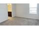 Bright, freshly carpeted bedroom showcasing an en-suite bathroom view with modern fixtures and natural light from the window at 11070 Longleaf Woods Dr, Orlando, FL 32832