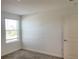 This bedroom has a window providing natural light and neutral colored walls and carpet at 11070 Longleaf Woods Dr, Orlando, FL 32832