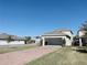 Exterior elevation view of a home's detached two car garage and brick paver driveway at 11070 Longleaf Woods Dr, Orlando, FL 32832