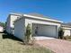Exterior view of a detached garage, featuring a red brick driveway and manicured lawn at 11070 Longleaf Woods Dr, Orlando, FL 32832