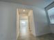Neutral hallway featuring tiled flooring, leading to rooms bathed in natural light at 11070 Longleaf Woods Dr, Orlando, FL 32832