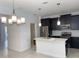 This open-concept kitchen features dark cabinetry, stainless appliances, and a center island at 11070 Longleaf Woods Dr, Orlando, FL 32832