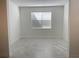 Bright, airy room with white walls, large window, and neutral tile flooring at 11070 Longleaf Woods Dr, Orlando, FL 32832