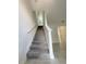 Carpeted staircase with white banister leading to the upper level, complemented by tiled flooring at 11070 Longleaf Woods Dr, Orlando, FL 32832