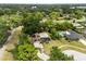 Aerial shot showcases a solar home with a kidney-shaped pool nestled in a mature, tree-filled residential neighborhood at 12 Horseman Cv, Longwood, FL 32750