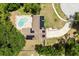 Overhead view of a solar-paneled home featuring a kidney-shaped pool, a well-kept yard, and a circular driveway at 12 Horseman Cv, Longwood, FL 32750
