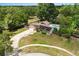 Stunning aerial view of a solar paneled home with a private pool and a well-manicured lawn in a lush, green neighborhood at 12 Horseman Cv, Longwood, FL 32750