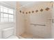 Bathroom featuring a tile shower with safety bar and neutral decor at 12 Horseman Cv, Longwood, FL 32750