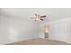 Carpeted bedroom features a ceiling fan, closet, and entry to the bathroom at 12 Horseman Cv, Longwood, FL 32750