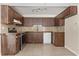 Functional kitchen boasts wood cabinets, tile floors, and modern appliances at 12 Horseman Cv, Longwood, FL 32750