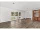 Spacious living room featuring hardwood floors, white walls, and large windows at 12 Horseman Cv, Longwood, FL 32750