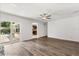 Large living room with wood floors, sliding glass door to the patio, and ceiling fan at 12 Horseman Cv, Longwood, FL 32750