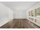 Bright living room features hardwood floors, white walls, and large windows with plantation shutters at 12 Horseman Cv, Longwood, FL 32750